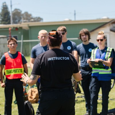 an instructor faces a group of students in public safety and first responder uniforms