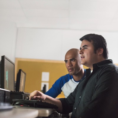 two students looking at a computer monitor